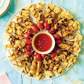Chicken skewers arranged in a circle around dipping sauce
