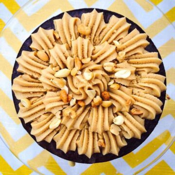 Over head image of peanut butter brownie cake with buttercream frosting and nuts