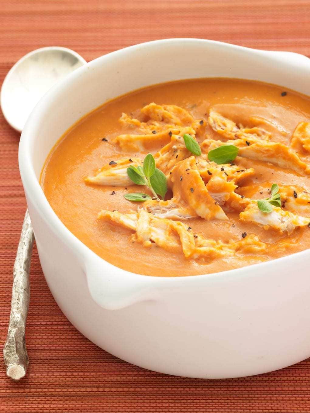 Chicken Tomato Bisque in a white bowl with large spoon