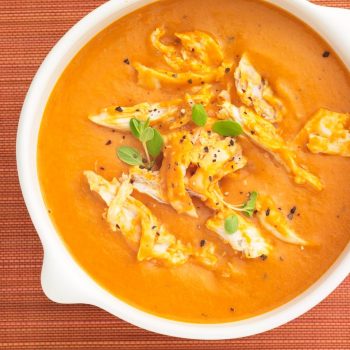 Close up image of Chicken Tomato Bisque on orange background