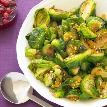 brussels sprouts in white bowl on purple linen