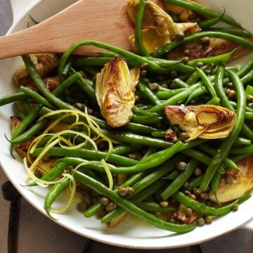 Green beans with capers and artichokes in pan