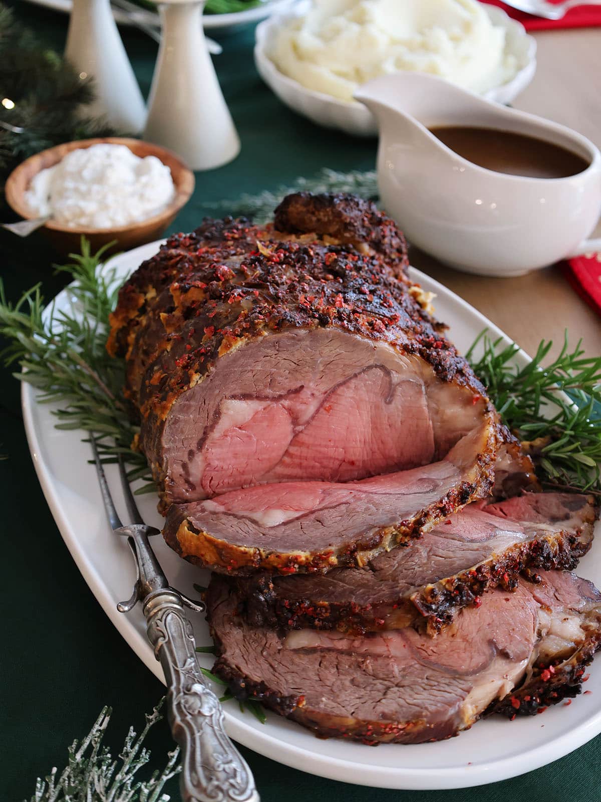 Prime rib cut into a few slices on a decorated platter.