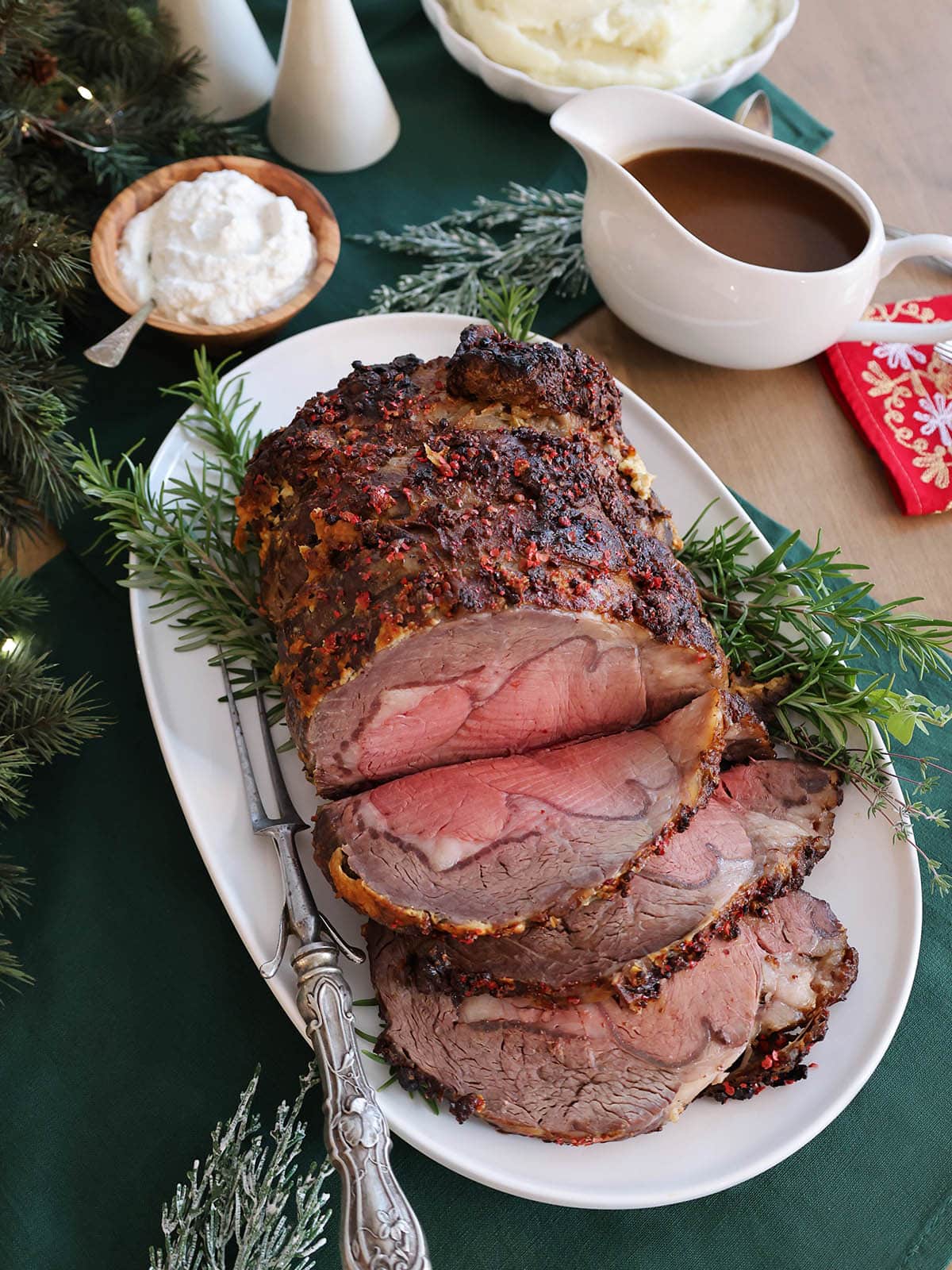 Prime rib cut into a few slices on a decorated platter.
