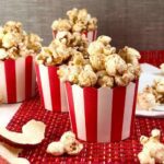 Apple cinnamon popcorn in red and white cups close up