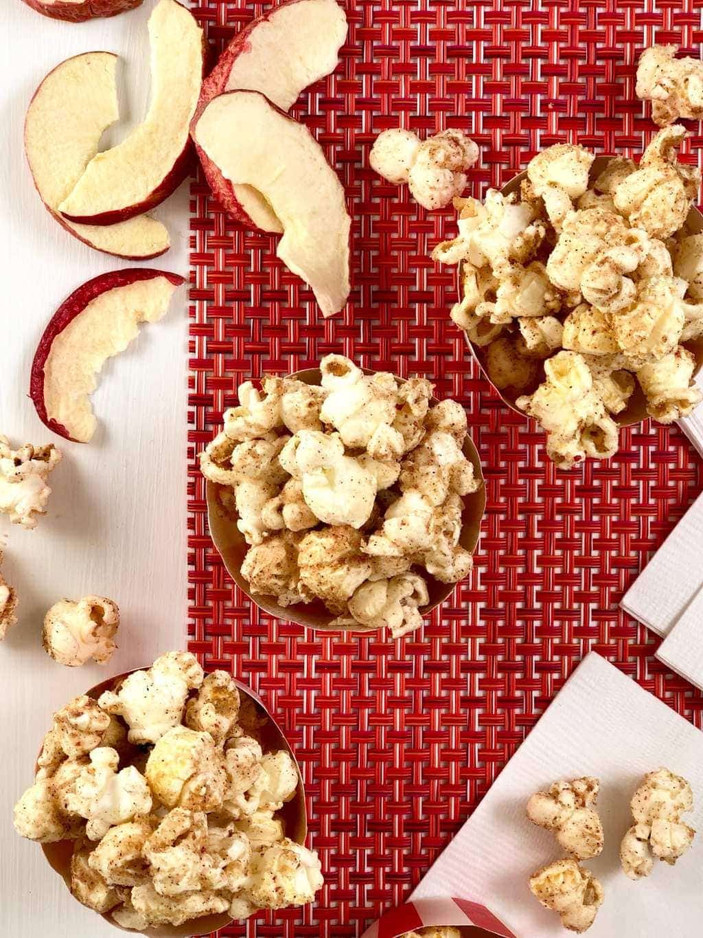 Apple cinnamon popcorn in red and white cups overhead