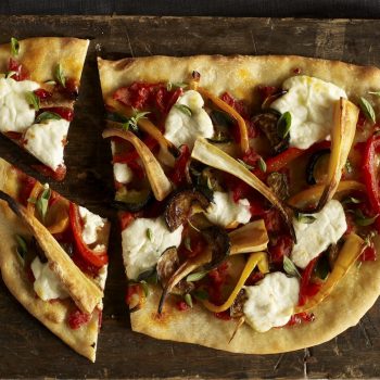 Shriveled Ogre Nose Pizza sliced on wood cutting board