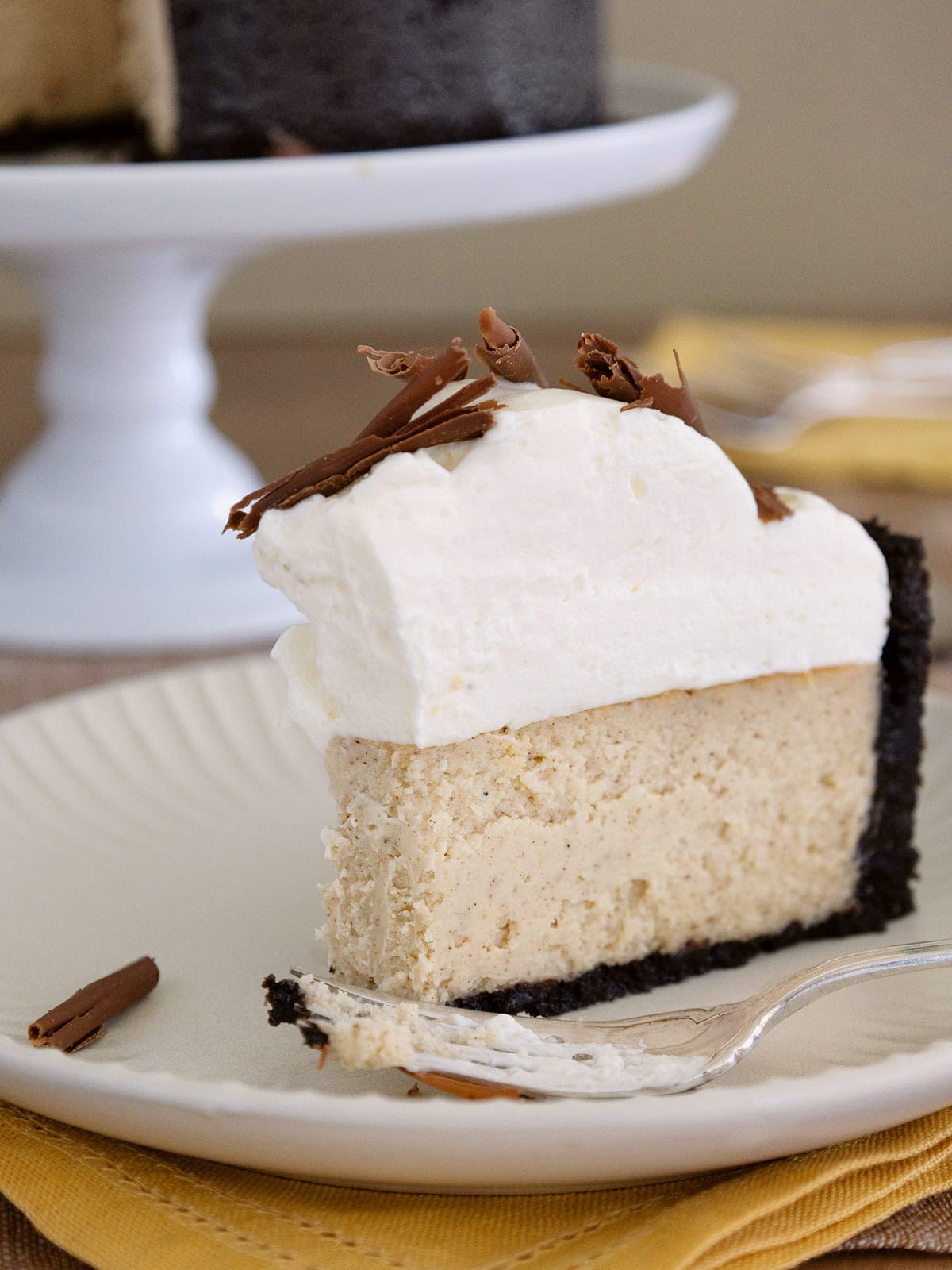 A slice of ginger cheesecake on a plate with a bite taken out of it.