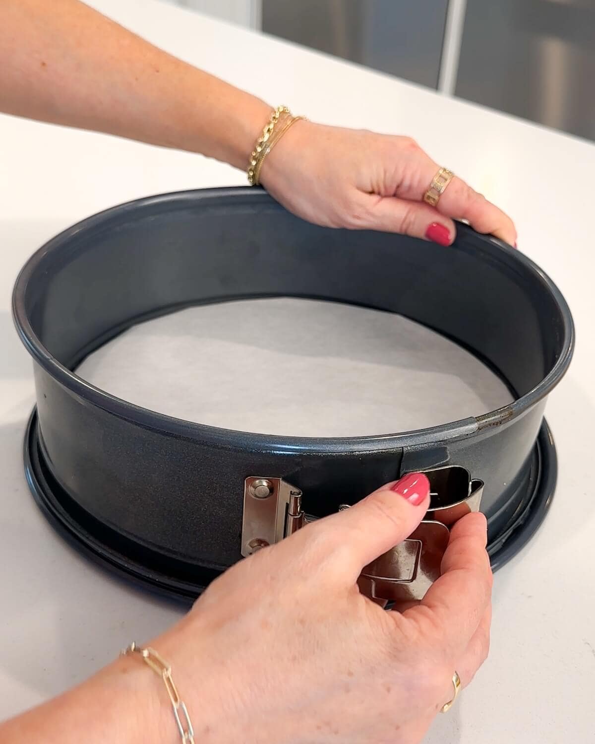 Lining the bottom of a springform pan with a parchment circle.