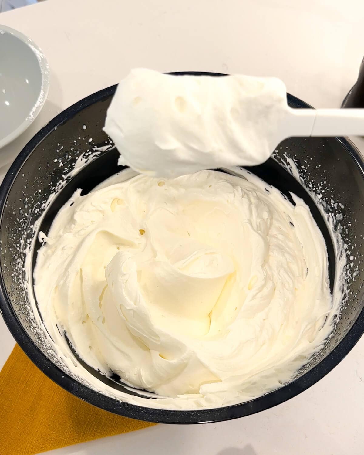 Stabilized whipped cream in a bowl at firm peaks stage.