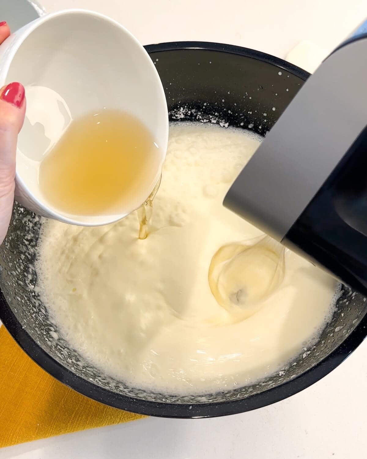 Adding cooled gelatin to whipped cream.