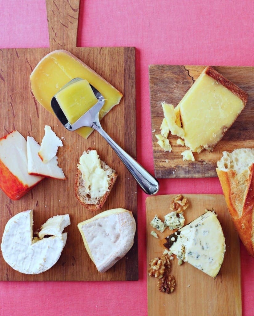 Cheeses on boards and pink background