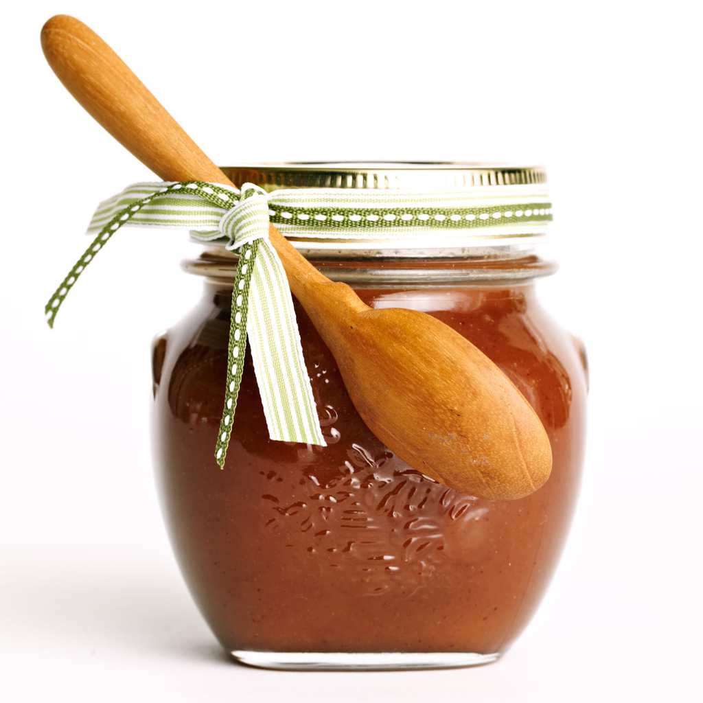 gingerbread caramel sauce in a small jar with a wooden spoon