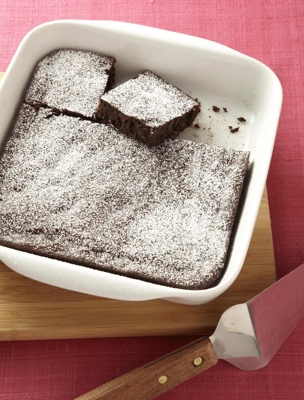 Fudgy Squash Brownies are baked in a square pan and dusted with confectioners' sugar