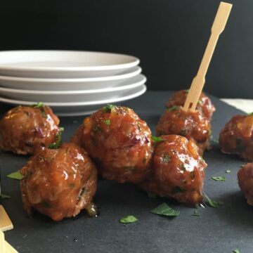 Chicken meatballs with cumin and orange on a cutting board