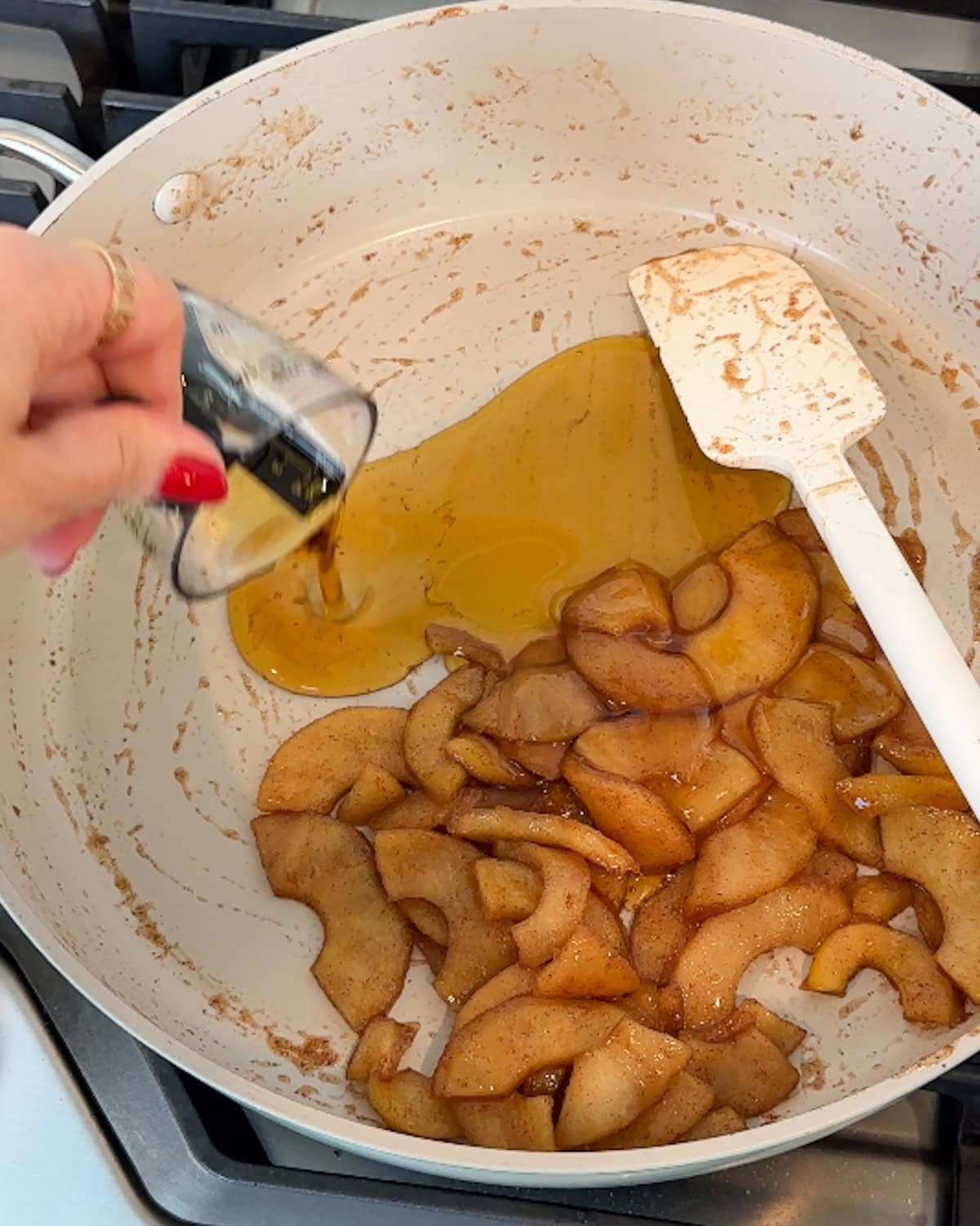 Adding maple syrup to stewed apples for French toast topping.