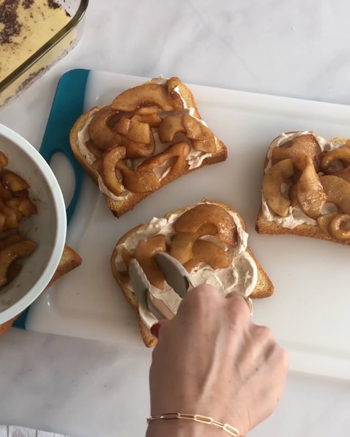Adding stewed apples to stuffed French toast.