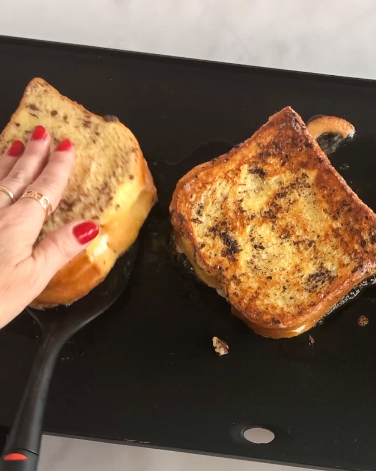 Flipping stuffed French toast to grill on the second side.