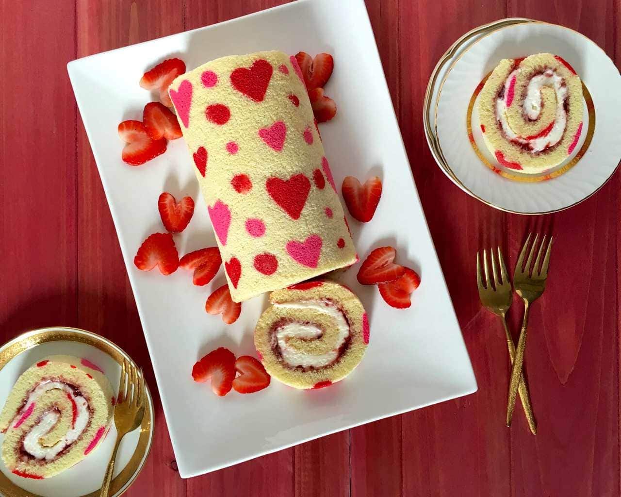 Overhead view of a strawberry roll cake decorated with hearts