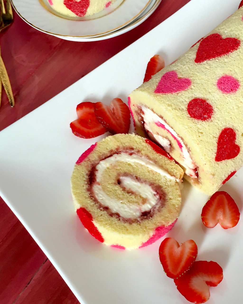 A strawberry jelly roll cake, sliced once