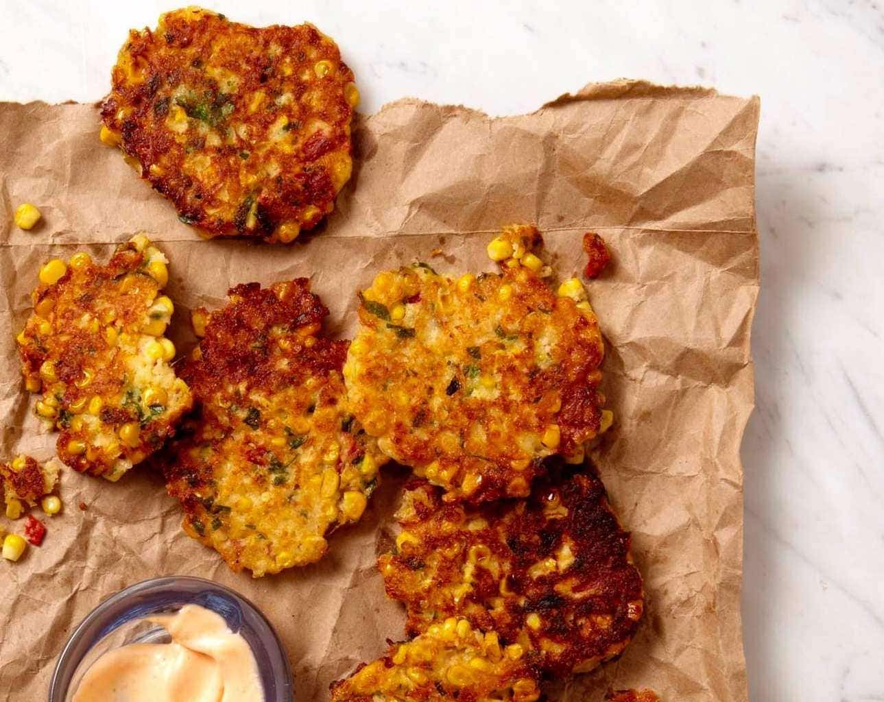 corn fritters with spicy mayo on brown paper