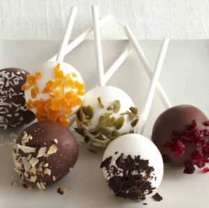Vanilla and chocolate covered cake pops decorated with dried fruits, nuts and cookies