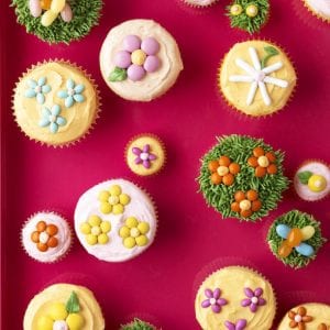 The cupcakes are decorated with little flowers and eggs made with delicious candy, on top of fluffy vanilla frosting.