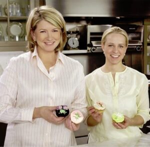 Martha Stewart and Tara Bench holding cupcakes in a kitchen