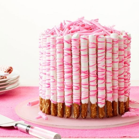 Mile high crunchy pretzels, covered in sweet chocolate, make this gasp-worthy Pink Pretzel Party Cake the star of your festivities.