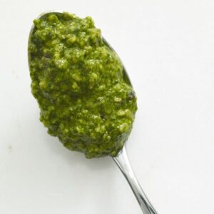 Close up image of dollop of Arugula Hazelnut Pesto on spoon