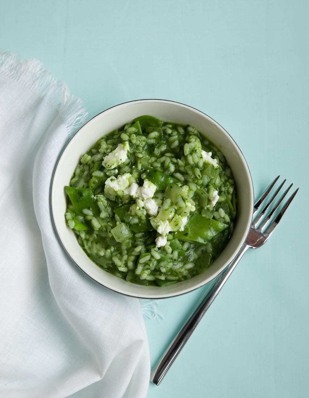 Spring Green Risotto in bowl with fork and white napkin