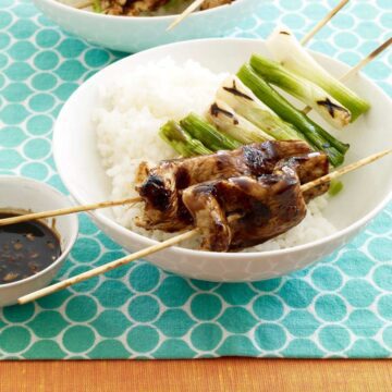 Close up of Teriyaki Chicken and Scallion Kabobs in white bowl