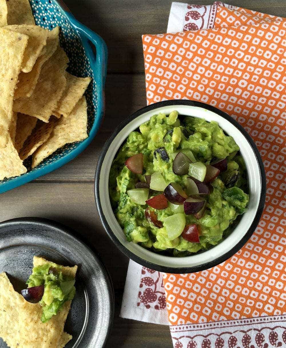 Summer Grape Guacamole w chips on orange napkin