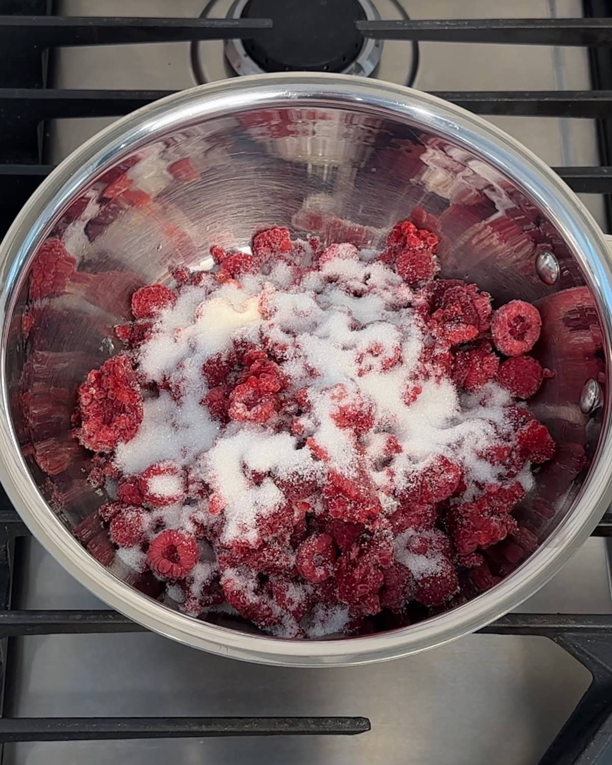 Raspberries and sugar in a small saucepan.