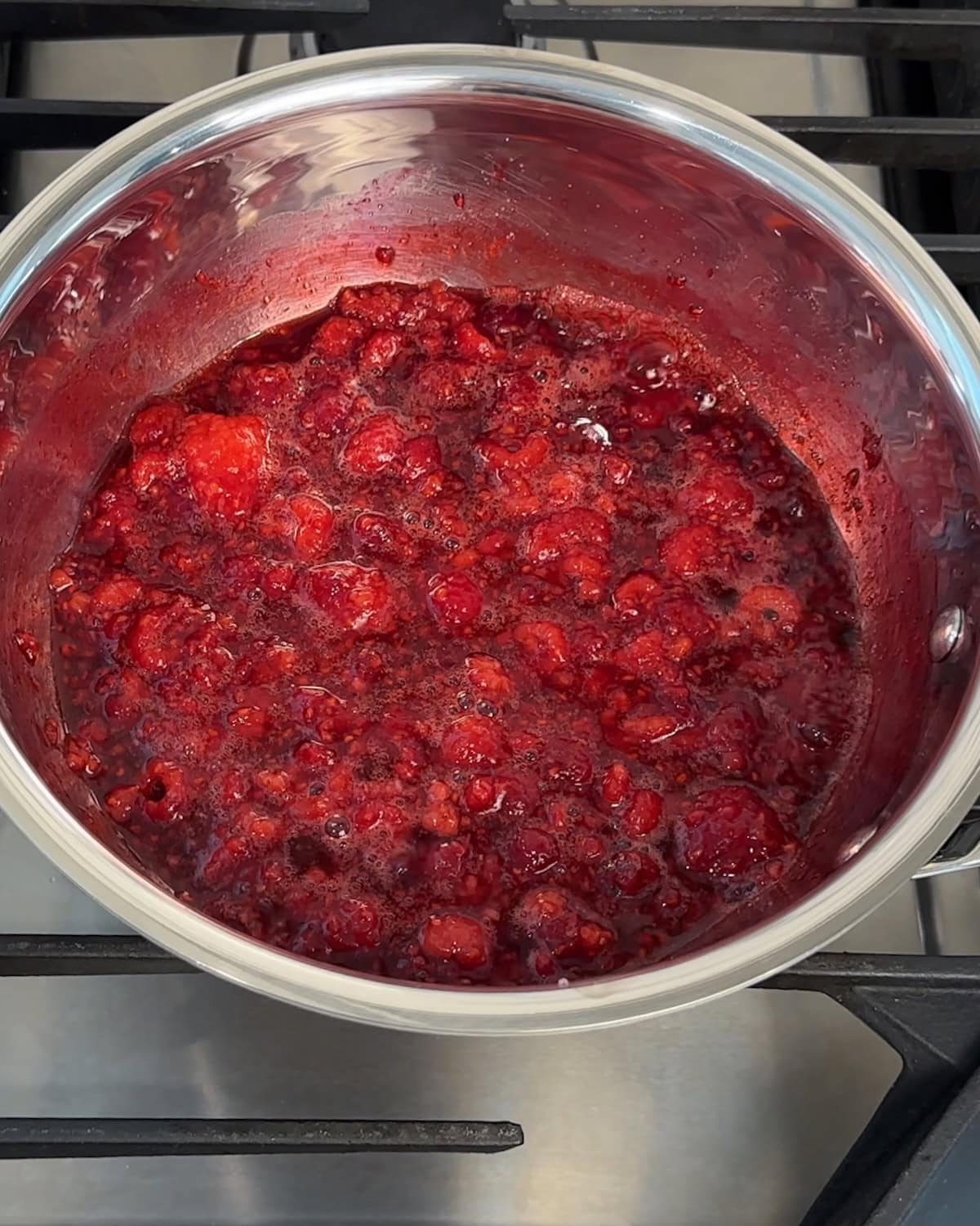 Finished raspberry sauce in a saucepan.