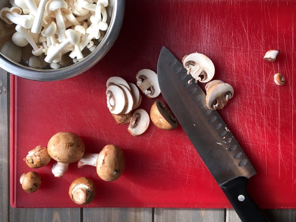 Easy Parmesan Mushroom Gnocchi w mix of earthy mushrooms on red w knife
