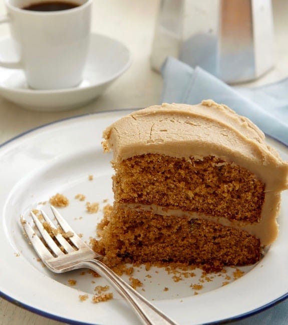 A slice of homemade spice cake on a white plate. A bite is missing. 