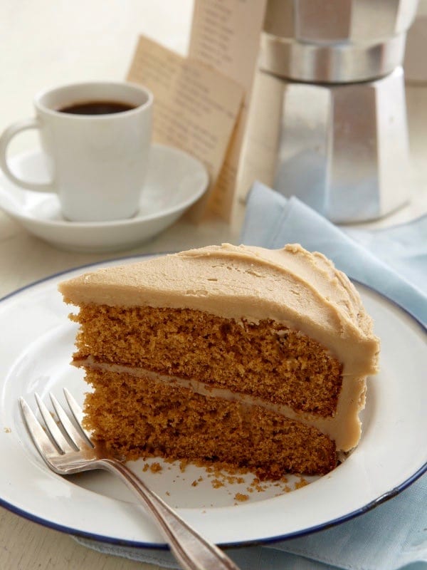 Spice Cake With Creamy Caramel Icing on a white plate with a fork