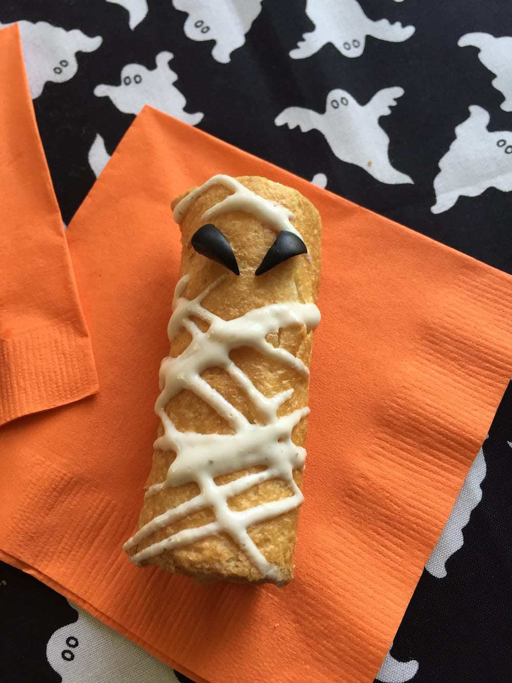 Pizza Roll Ups Mummy Snacks - single on orange napkin and ghosts
