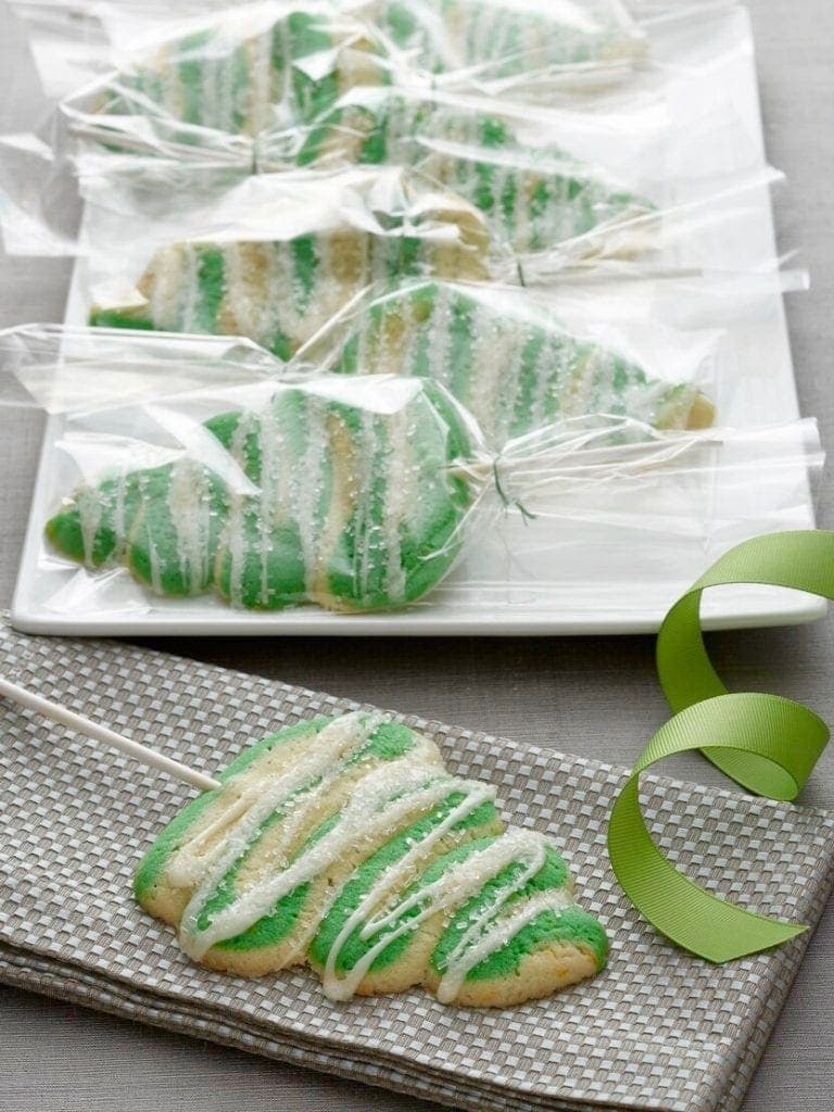 Christmas Tree Lollipop Cookies wrapped in clear plastic displayed on white platter