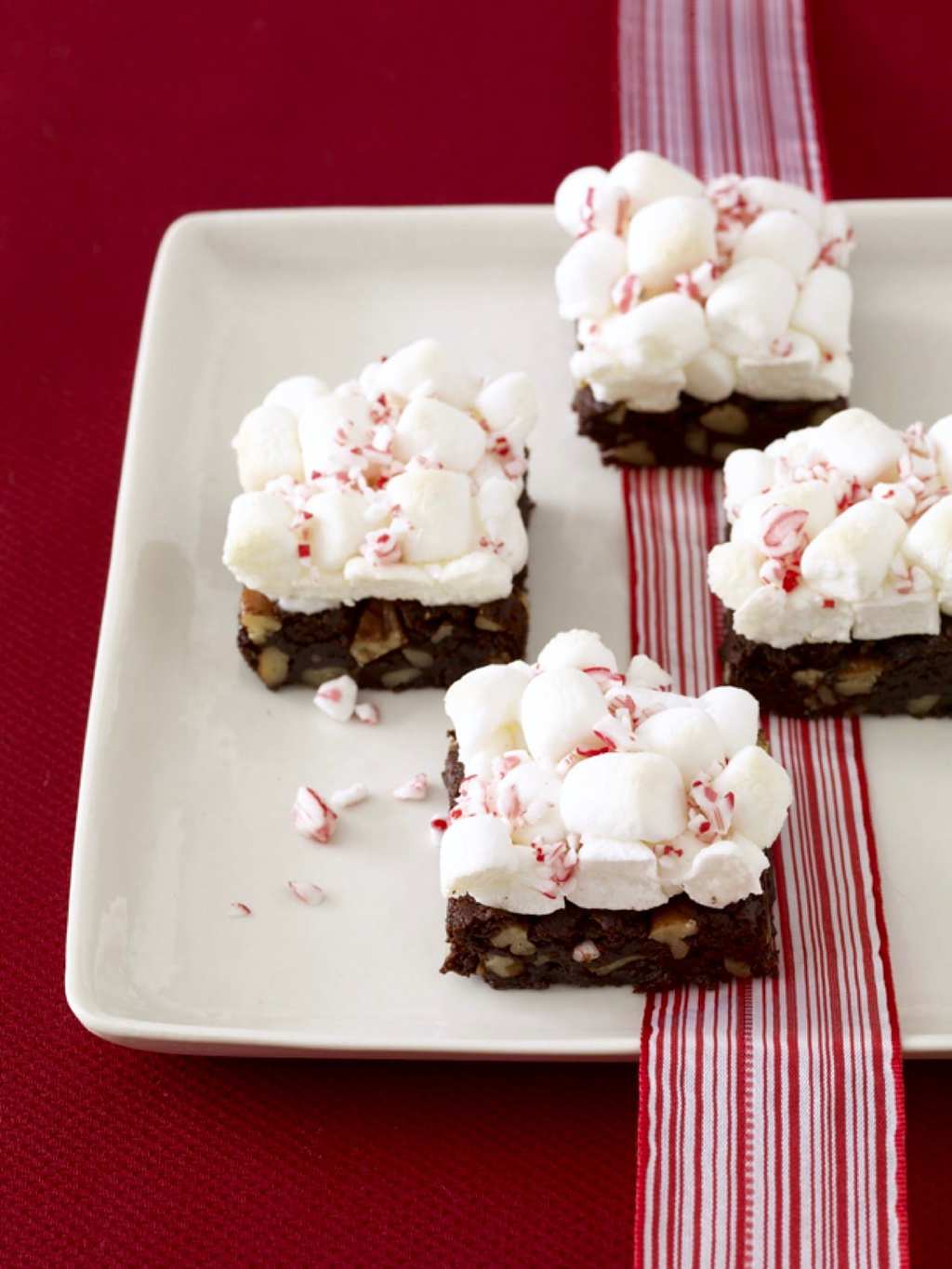 Peppermint brownies with marshmallows on a red table with ribbon