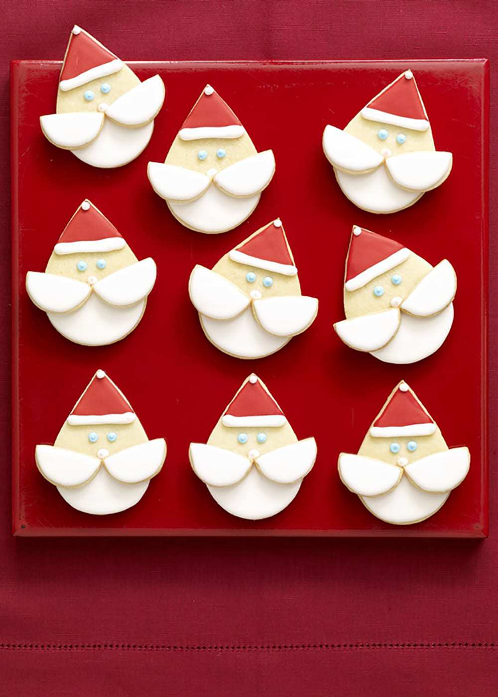 Santa face cookies on red platter and red linen
