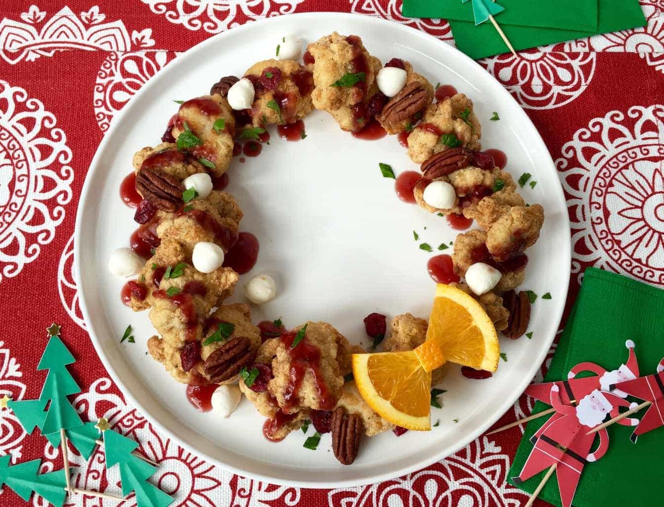 Chicken bites Christmas wreath appetizer on white plate, red and white linen, Christmas toothpicks