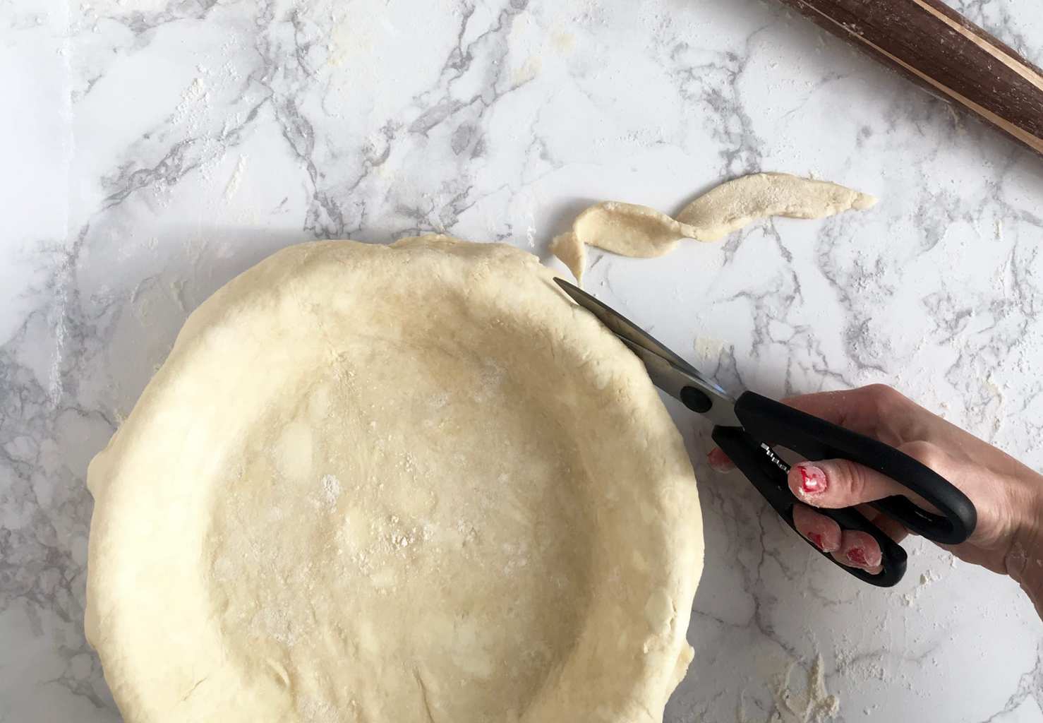 Rolling the perfect pie crust trimming edge with scissors