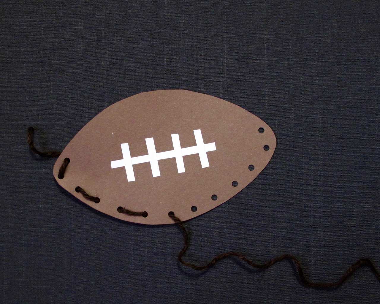 Football with stitching and woven edge on gray backgound