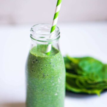 Green Goddess Smoothie recipe image with spinach leaves on the side