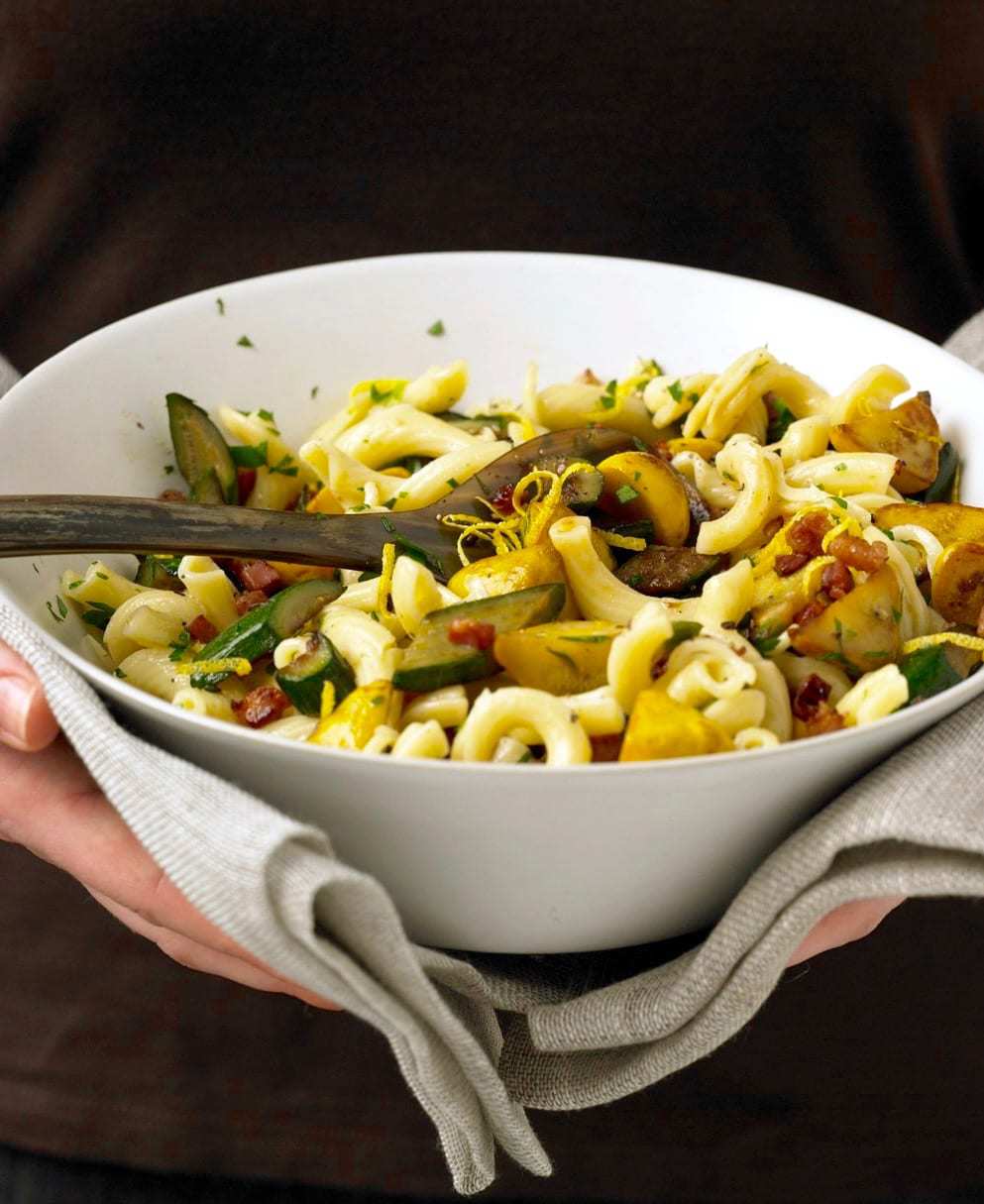 Squash and Pancetta pasta held in white bowl with linen napkin