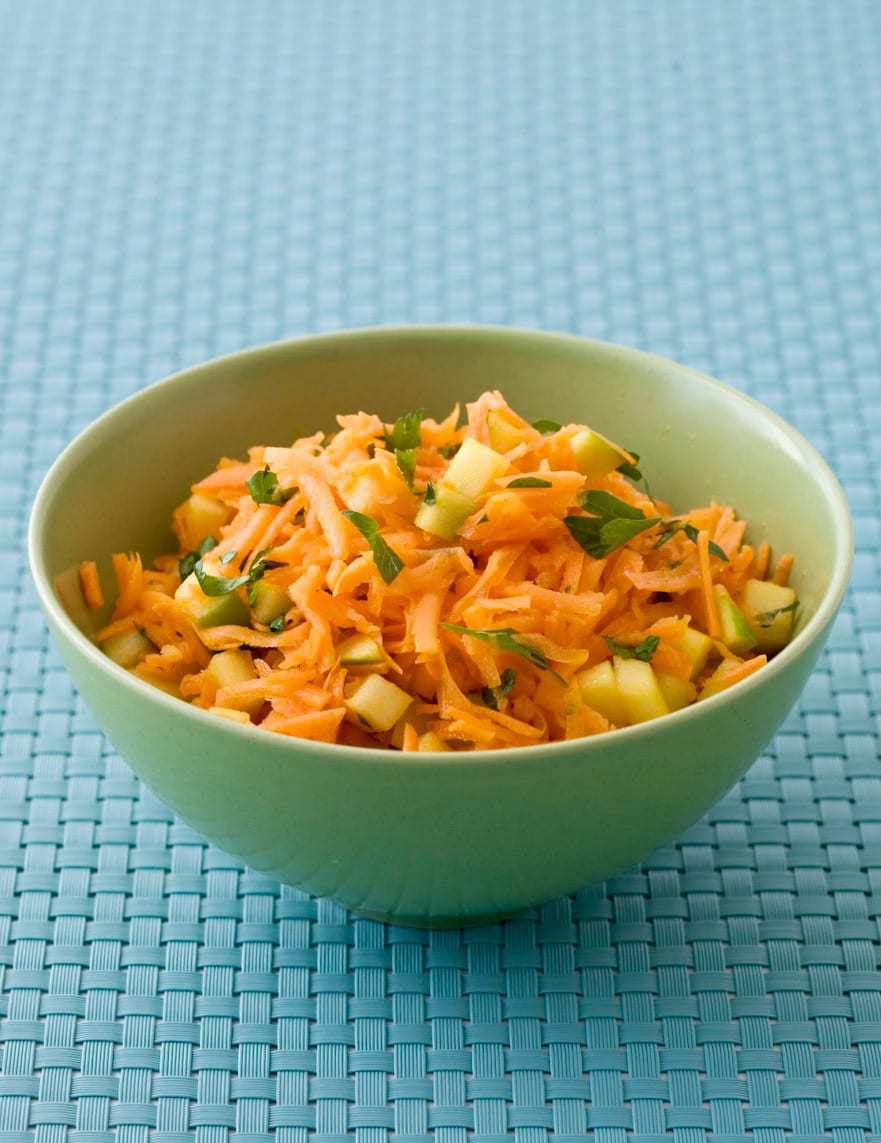 Shredded Carrot Salad with Apples and Lime in lime green bowl on turquoise placemat - close crop
