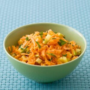 Shredded Carrot Salad recipe image in green bowl on blue surface