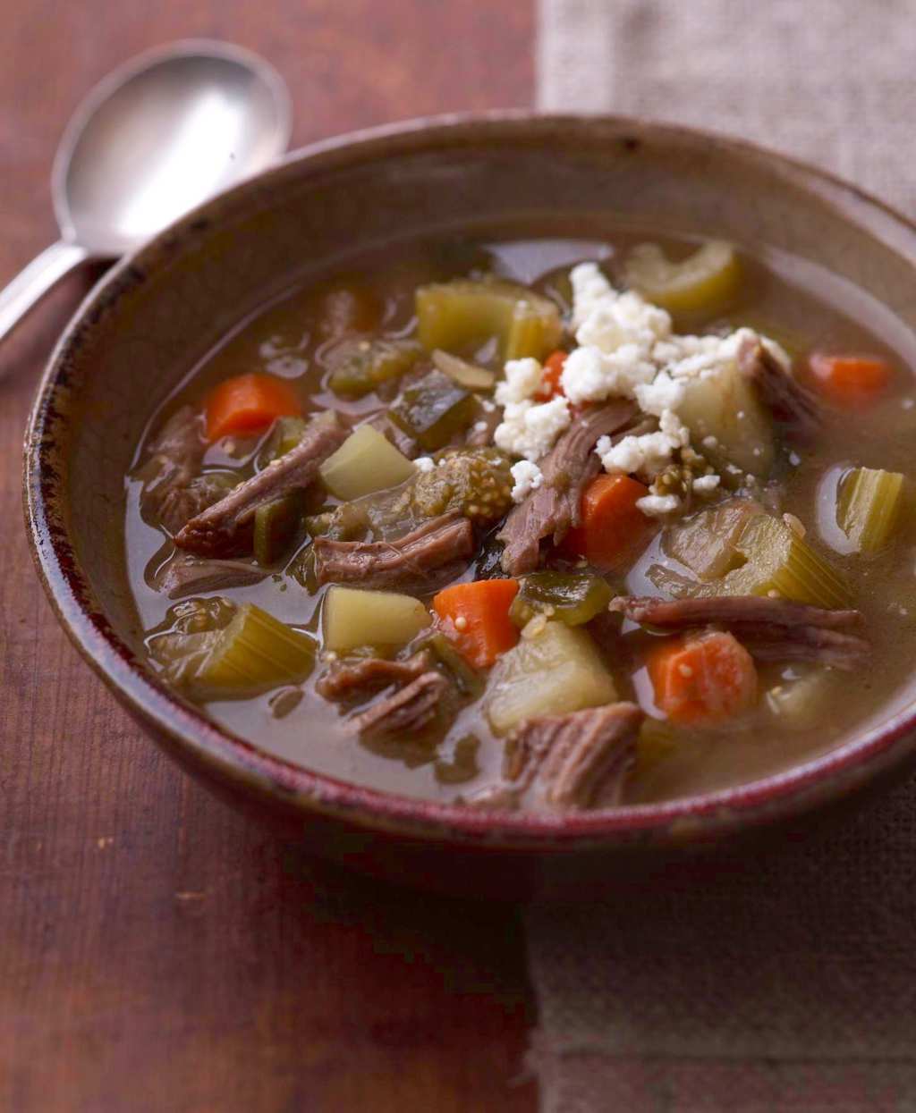 Mexican Tomatillo and Shredded Beef soup in bowl with spoon